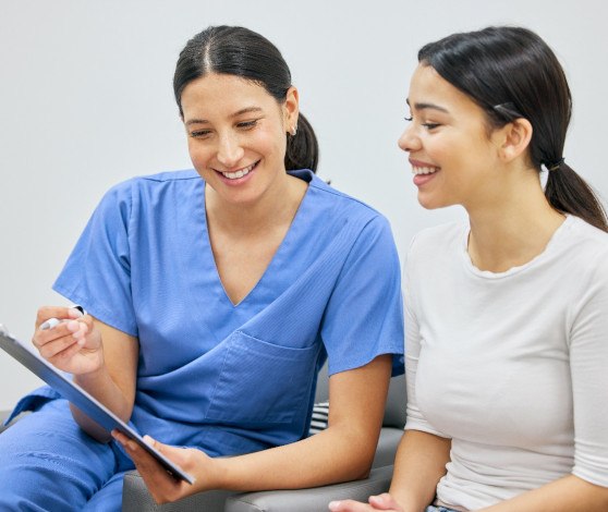 Patient and dental team member looking at clipboard