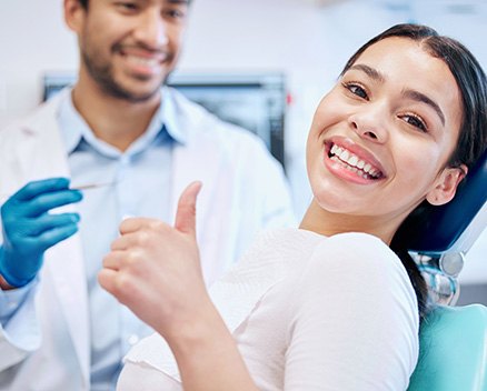 Happy dental patient making thumbs up gesture