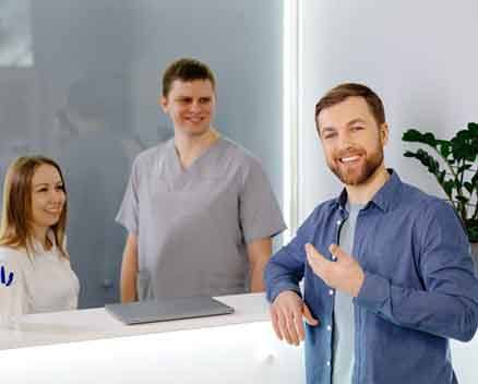 Happy patient standing at dental office front desk