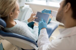 Dentist and patient looking at tablet during smile makeover consultation